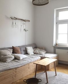 a living room filled with furniture and a large wooden bench in front of a window