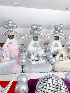 a room filled with lots of silver balloons and decorations on top of white sheets covered flooring