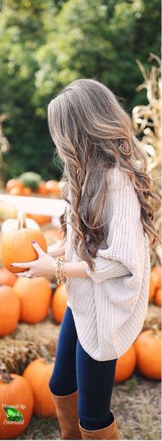 a woman holding a pumpkin in her hand