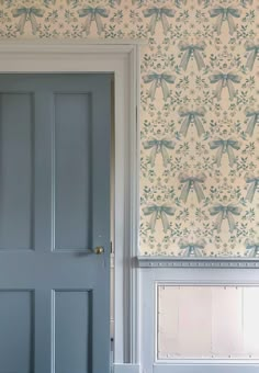 a blue door and wallpaper in a room