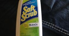 a bottle of soft scrub sitting on top of a pair of jeans