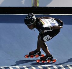 a man riding roller blades on top of a blue surface