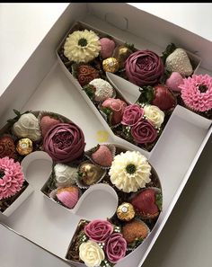 two white boxes with pink and white flowers in the shape of the letter e on them