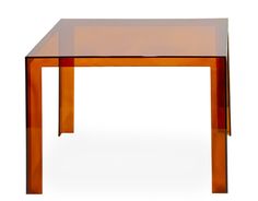 an orange glass table on a white background with no people in the room around it