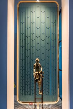 a statue sitting on top of a wooden chair in front of a blue wall and window