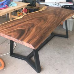 a large wooden table sitting inside of a garage next to other workbench tools