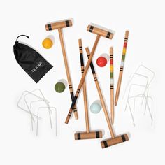 an assortment of wooden croquets and balls on a white background with a black bag