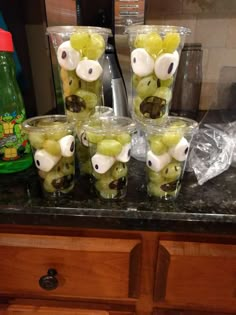 several glasses filled with grapes in the shape of animals sitting on top of a counter