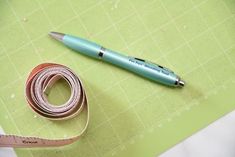 a roll of tape next to a pen and ruler