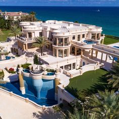 this is an aerial view of a mansion on the beach in palm trees and blue water