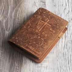 a brown leather journal sitting on top of a wooden table