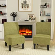 two green chairs sitting in front of a fire place