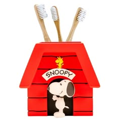 a red doghouse with toothbrushes in it and snoopy on the roof