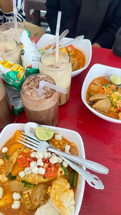 several bowls of food on a red table