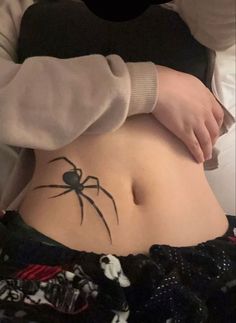 a person with a spider tattoo on their stomach and the bottom part of her belly