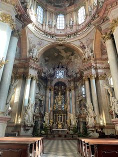 the inside of a church with many statues on it's walls and windows above