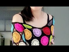 a woman is wearing a colorful crochet top