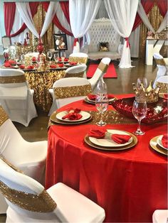 a banquet room set up with red and gold table cloths, white chairs, and silverware