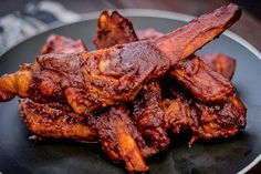 some meat is on a black plate and ready to be eaten by the person in the photo