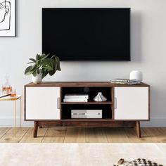 an entertainment center with a flat screen tv mounted on it's wall, in a living room