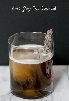 a glass filled with tea and ice on top of a table