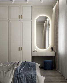 a bedroom with white cabinets and a large round mirror above the bed, along with a blue stool