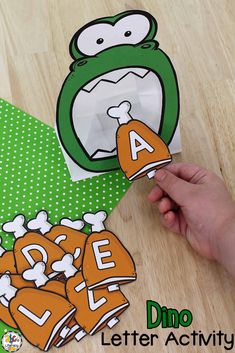 a hand holding an orange and white paper bag with the letter a in front of it