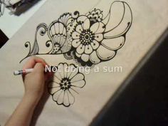 someone is drawing flowers on a piece of paper