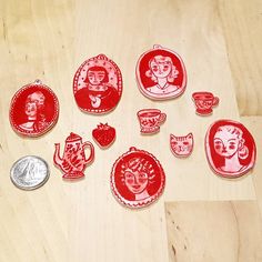 some red and white magnets sitting on top of a wooden table next to a penny