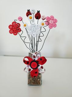 a vase filled with buttons and flowers on top of a table