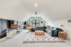 a large living room with white carpet and black couches