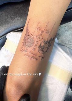 a person with a tattoo on their leg that has an angel in the sky above it