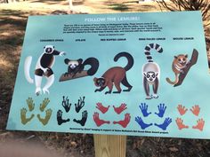 a sign showing the different kinds of animals and their names in front of some trees