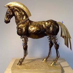 a bronze statue of a horse with gold manes and bells on it's legs