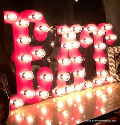 a large light up sign that says happy birthday on it's side with lots of lights around the letters