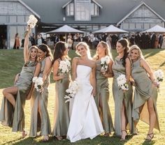 a group of women standing next to each other on top of a grass covered field