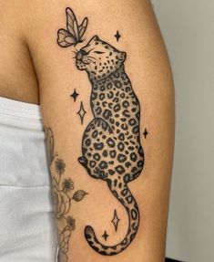 a woman's arm with a tattoo on it that has a leopard and butterfly on it