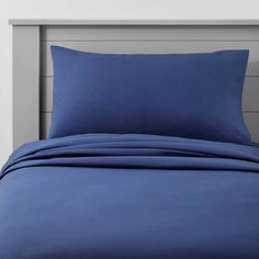 a bed with blue sheets and pillows on it