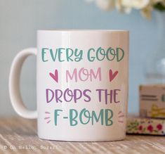 a coffee mug that says, every good mom drops the f - bomb on it