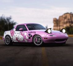 a pink car with hello kitty painted on it