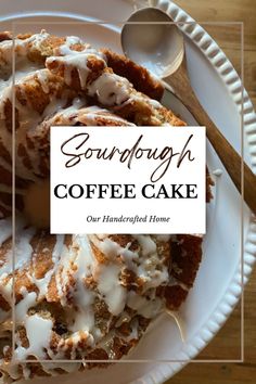 a white plate topped with coffee cake covered in icing next to a wooden spoon