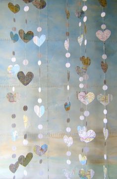 several hearts hanging from strings in front of a blue sky