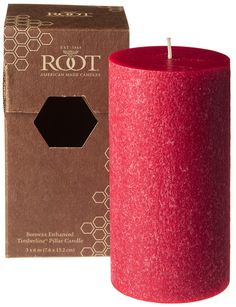 a red candle sitting next to a cardboard box