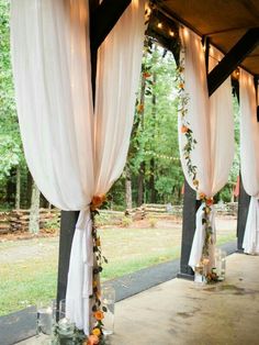 an outdoor wedding venue with white drapes and candles