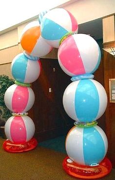 large inflatable beach balls are on top of each other at the entrance to an office building