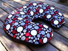 a black and red polka dot pillow sitting on top of a wooden floor