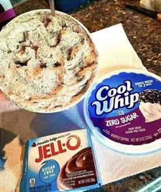 someone is holding a bowl of jello and some ice cream on a counter top