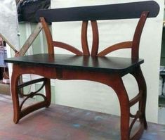 a wooden bench sitting on top of a hard wood floor next to a white wall