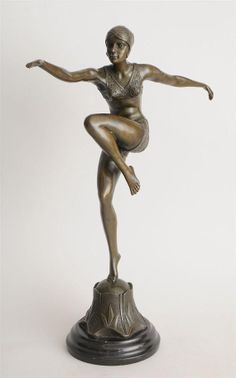 a bronze statue of a woman on top of a pedestal with her arms spread out