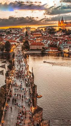 many people are walking on the bridge over the water in prague, czech at sunset